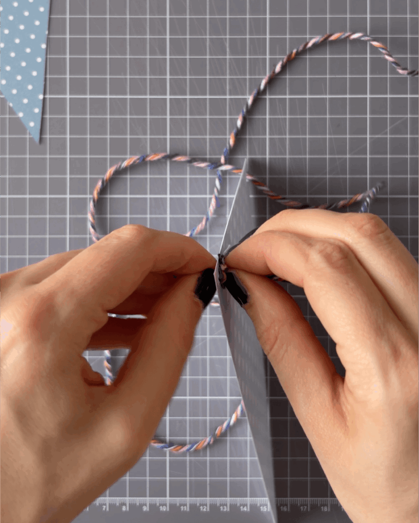 Thread baker's twine, string or ribbon through the holes.